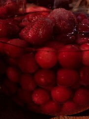 Home spins. Strawberry and sweet cherry compote. Red berries, water and sugar in a jar. Macro...
