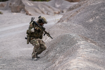 Modern Soldiers on Recon Mission – Two Armed Men in Military Camouflage Patrolling a Rocky...