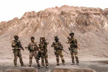 Special Forces Team Standing Together in Desert Mountain Terrain – Tactical Soldiers in Full Gear...