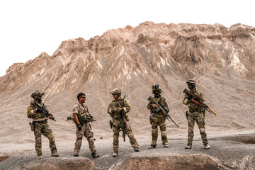 Special Forces Team Standing Together in Desert Mountain Terrain – Tactical Soldiers in Full Gear with Rifles, Communicating and Coordinating During a Military Operation or Training Mission