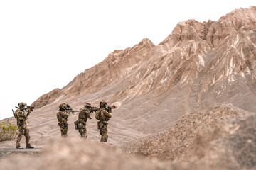 Special Forces Team Standing Together in Desert Mountain Terrain – Tactical Soldiers in Full Gear...