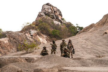 Special Forces Team Standing Together in Desert Mountain Terrain – Tactical Soldiers in Full Gear...