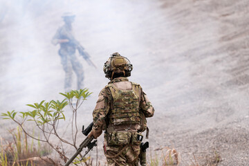 Special Forces Soldier Standing in Smoke During Tactical Operation – Full Combat Gear with Rifle and Helmet in Action Scene, Military Training or Battlefield Simulation Environment