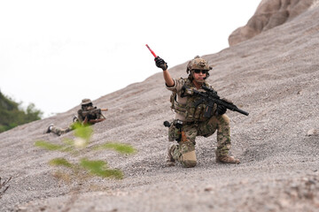 Special Forces Team During Military Operation on Rocky Slope – Soldier Holding Red Flare and...