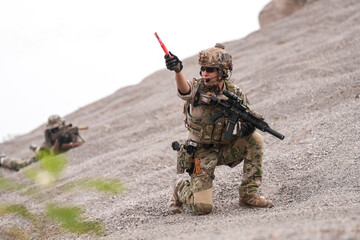 Special Forces Team During Military Operation on Rocky Slope – Soldier Holding Red Flare and...