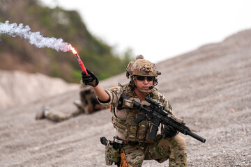 Special Forces Team During Military Operation on Rocky Slope – Soldier Holding Red Flare and...