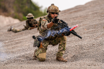 Special forces soldier uses a radio during a tactical operation while red flare smoke spreads...