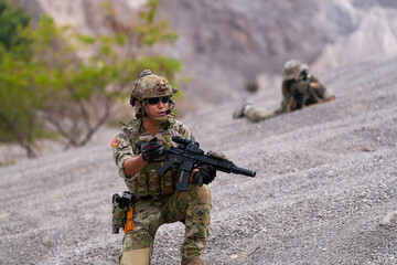 Special forces soldier uses a radio during a tactical operation while red flare smoke spreads...