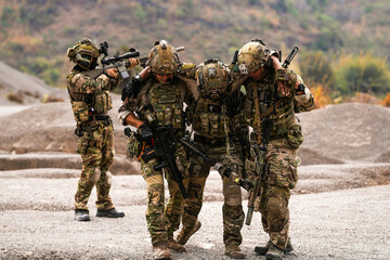 Injured Soldier Being Carried by Teammates in Full Tactical Gear During Battlefield Extraction – Military Brotherhood, Combat Rescue, Support Under Fire
