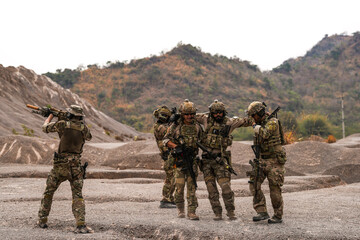 Injured Soldier Being Carried by Teammates in Full Tactical Gear During Battlefield Extraction –...
