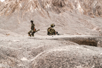 Three Soldiers in Combat Gear Holding Tactical Positions on Rocky Terrain – Realistic Military Operation Scene with Teamwork, Readiness, and Strategic Communication