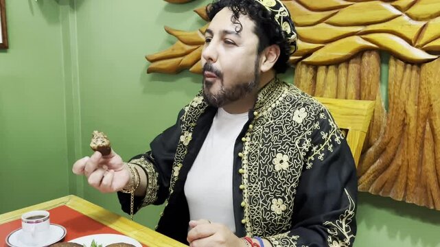 Horizontal 4k video of a Lebanese man enjoying his delicious traditional meal while smiling, with his hands taking the Kibbeh to accompany his hummus.	
