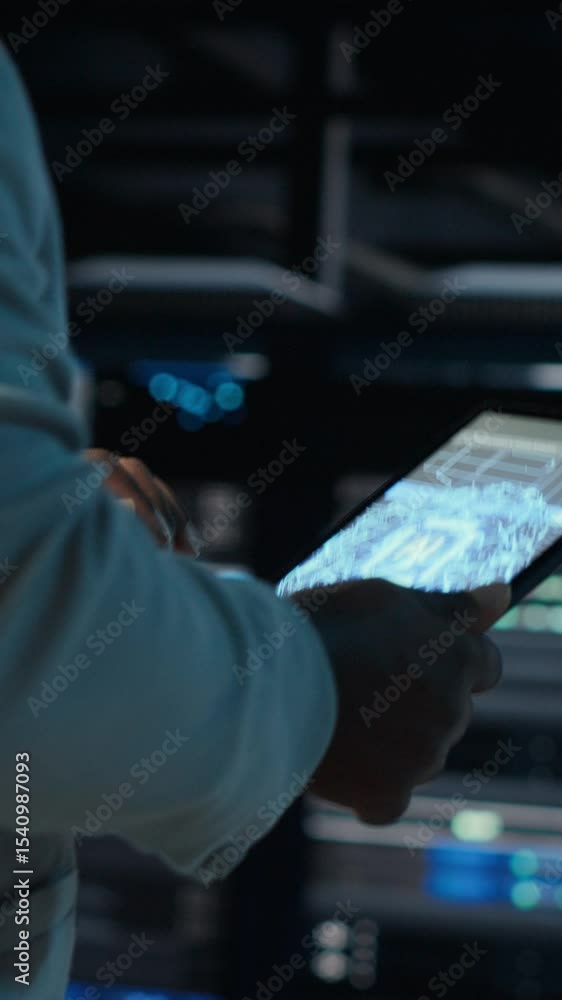 Poster vertical video system administrator walking in data center with walls lined with modern supercompute