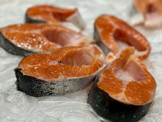 Steaks of chilled Atlantic salmon from frozen raw materials on a substrate for sale in a supermarket. Close-up
