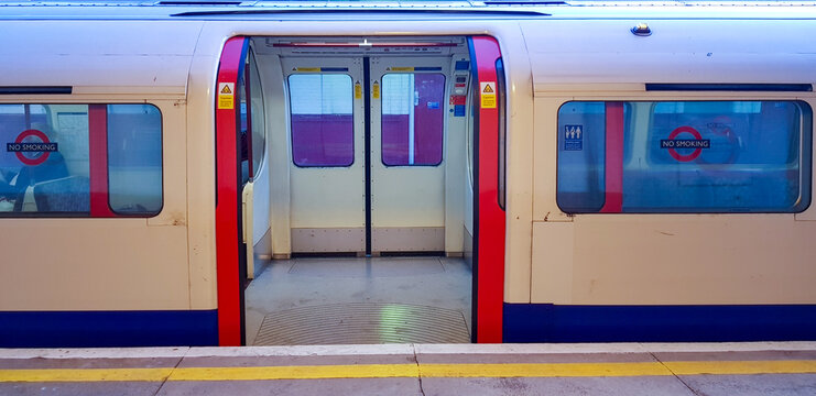 London Underground tube train with red doors open and no passengers. 