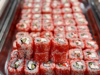 Indulge in these utterly Delicious Sushi Rolls beautifully Garnished with Bright Red Tobiko. Vibrant array of sushi rolls topped with red tobiko, perfect for food enthusiasts and cuisine photography