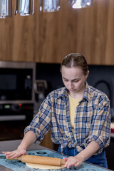 Woman skillfully rolls out dough, perfectly showcasing her culinary expertise in a kitchen