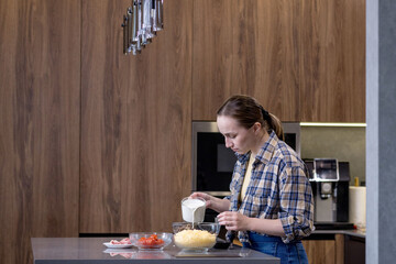 Young woman preparing quiche in the kitchen