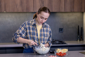 Young woman preparing quiche in the kitchen