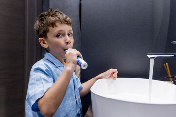 Cute little boy brushing his teeth in the bathroom