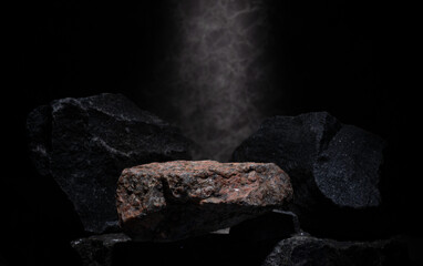 Fototapeta premium composition of stones for podium background.natural black stones with texture on dark background in minimalistic composition for presentation of cosmetics medicine fragrances jewelry products