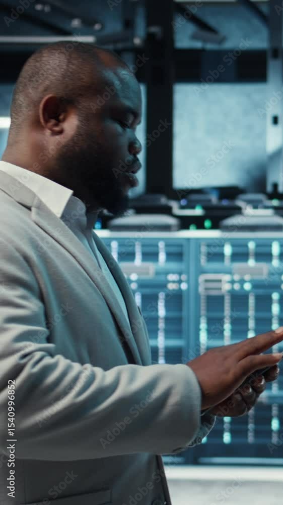Poster vertical video technician working in high tech server hub, analyzing data on tablet to ensure seamle