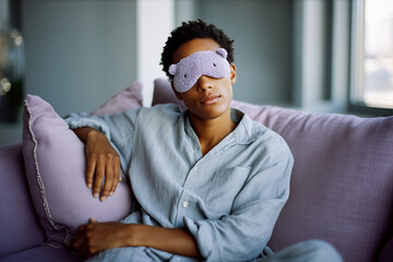 Obraz premium A woman is wearing a sleep mask and sitting on a couch