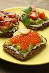 Different delicious avocado sandwiches on table, closeup