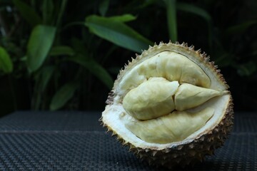 Fresh ripe durian on wicker table outdoors, closeup. Space for text