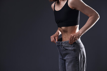 Woman suffering from anorexia on grey background, closeup. Space for text