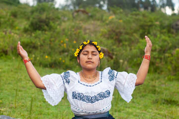Indigenous woman wearing traditional clothes performing ritual in nature
