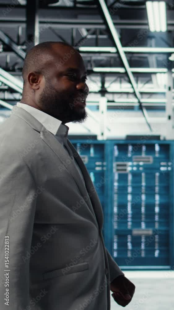 Poster vertical video engineer walking in data center facility, doing inspection on hardware tech handling 