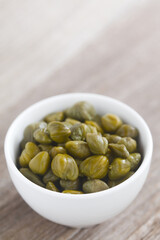 Pickled capers in small bowl with copy space in the back (Selective Focus, Focus one third into the...