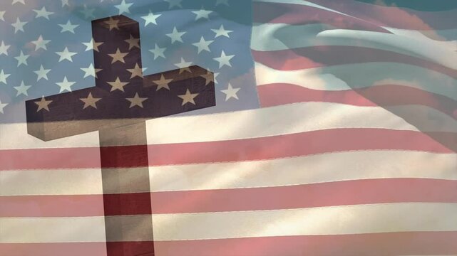 Wind picking up and causing American flag forming deep ripples behind cross creating memorial scene