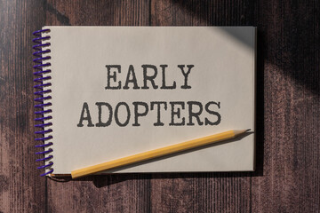 Businessman holding a card with text early adopters. concept