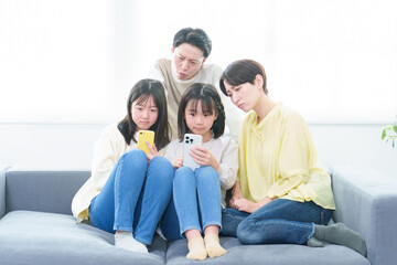 困った顔をしながらスマートフォンを使う親子
