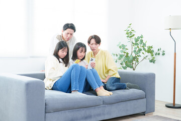 困った顔をしながらスマートフォンを使う親子