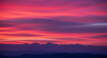 Naklejka premium Vivid Sunset Over Mountain Range with Dramatic Pink and Purple Sky (1)