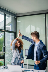 Happy business team cheering in office after project success. Celebration, teamwork victory, achievement