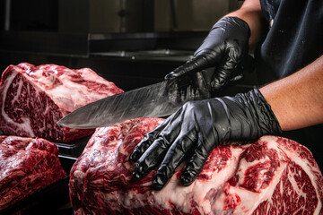 Butcher expertly cutting a marbled raw steak