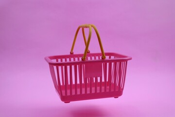 Pink Shopping Cart with Yellow Handle on pink Background