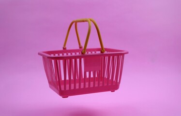 Pink Shopping Cart with Yellow Handle on pink Background