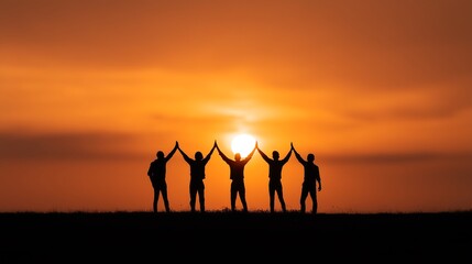 Silhouette of happy business team high-fiving against vibrant sunset sky, teamwork and success concept