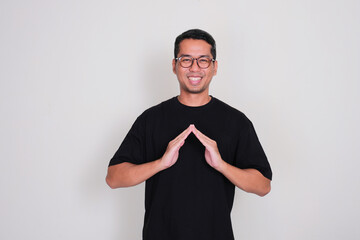Adult Asian man smiling happy with his hand making house shape