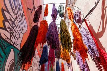 Scenic street view of market stalls and traditional Moroccan dyes for clothing in the Old Town...