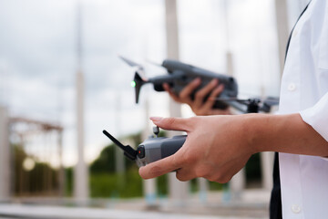 Engineer operating drone at construction site for industrial inspection and surveillance, ensuring safety, power infrastructure development, and environmental monitoring with advanced remote control t