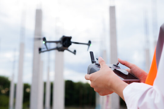 Engineer operating drone at construction site for industrial inspection and surveillance, ensuring safety, power infrastructure development, and environmental monitoring with advanced remote control t
