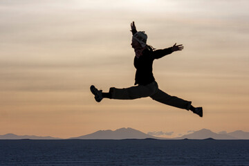 Silhouette Girl jumping on the Salar de Uyuni salt flats Bolivia