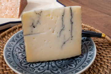 Tasty Spanish hard cheese, cow and sheep curado, manchego, goat cheese with added black truffle mushrooms, close up