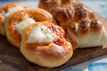 Fresh baked bread, pizza, focaccia or pizzetta with tomatoes, vegetables, sausage and cheese, street food in Palermo, Sicily, Italy, served outdoor for lunch